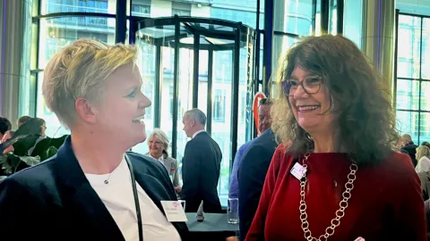 Two female leaders talking and smiling