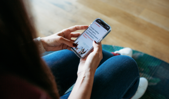 A girl sitting and checking her mobile phone